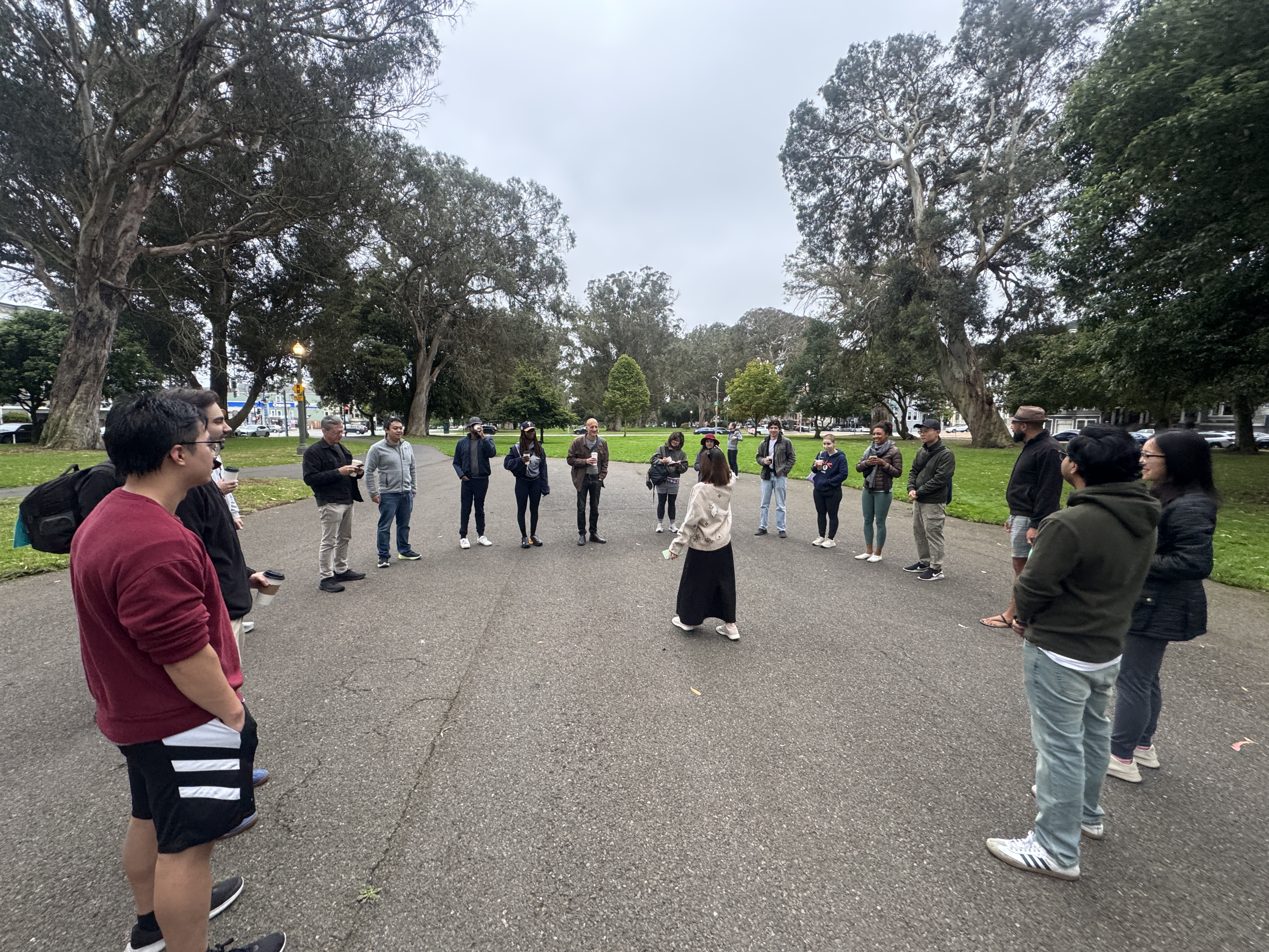 Walkers in a circle at Golden Gate Park, sharing topics before the walk.